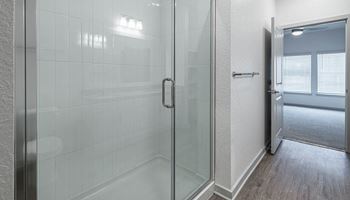 A white bathroom with a glass shower door